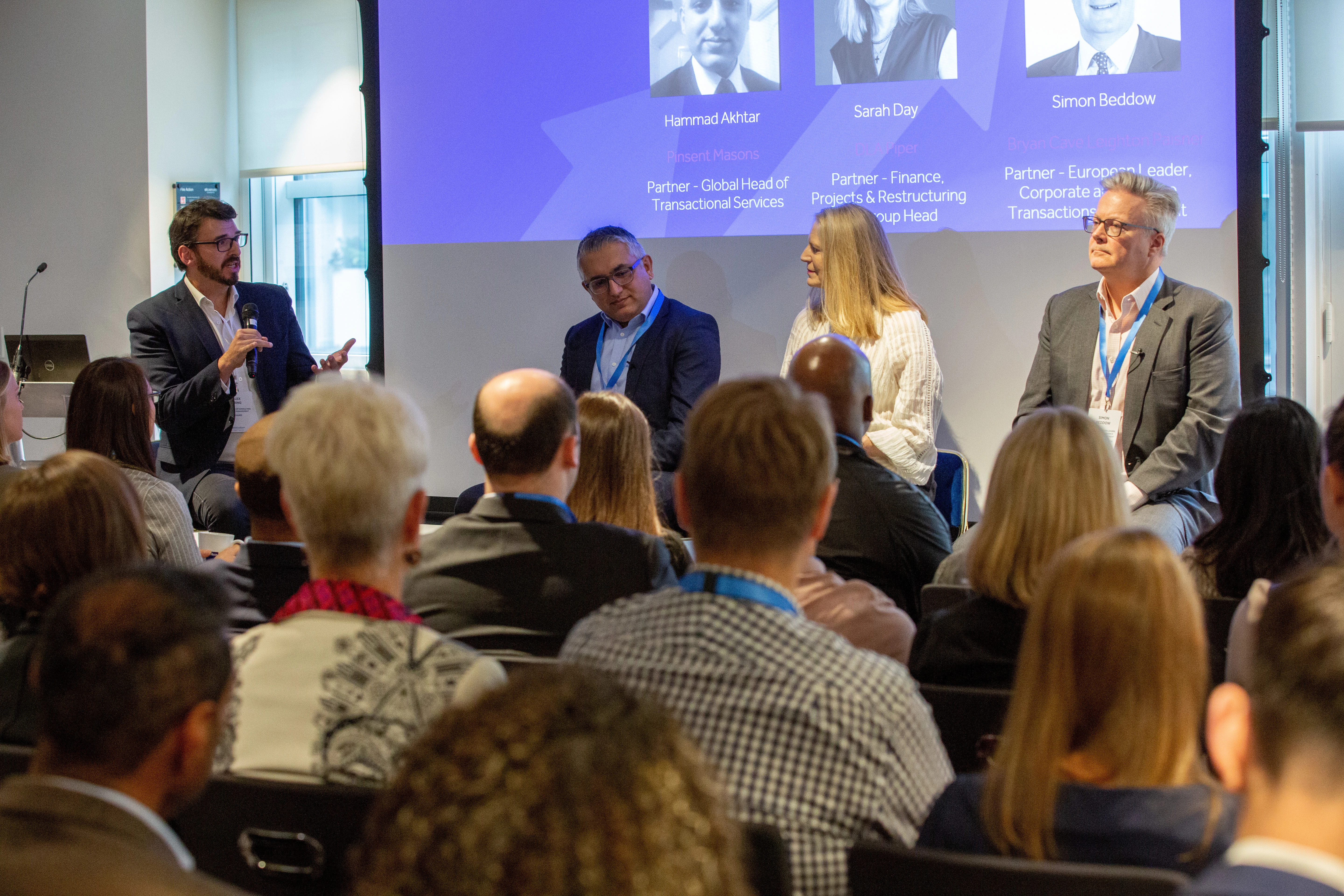 Four panellists discuss operational efficiency at law firms in front of a crowded room